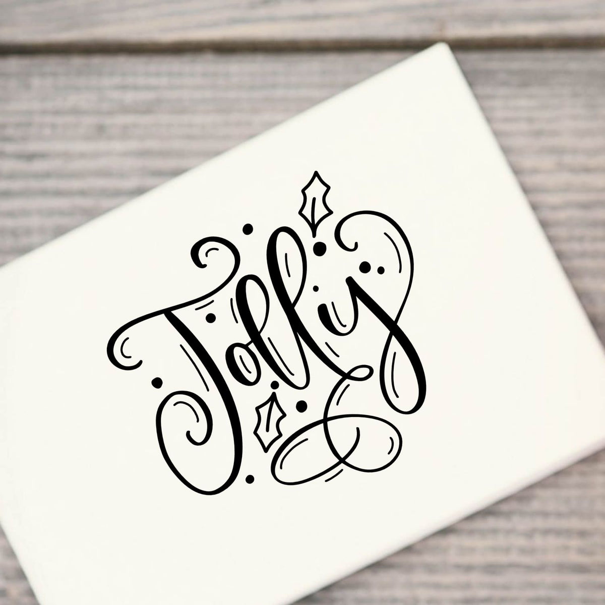 White stamp and seal featuring black ornate script logo with swirls and dots on a gray wood background.