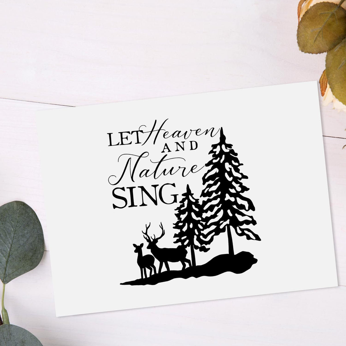 Black stamp and seal design reading Let Heaven and Nature Sing with pine trees and deer on a white card.
