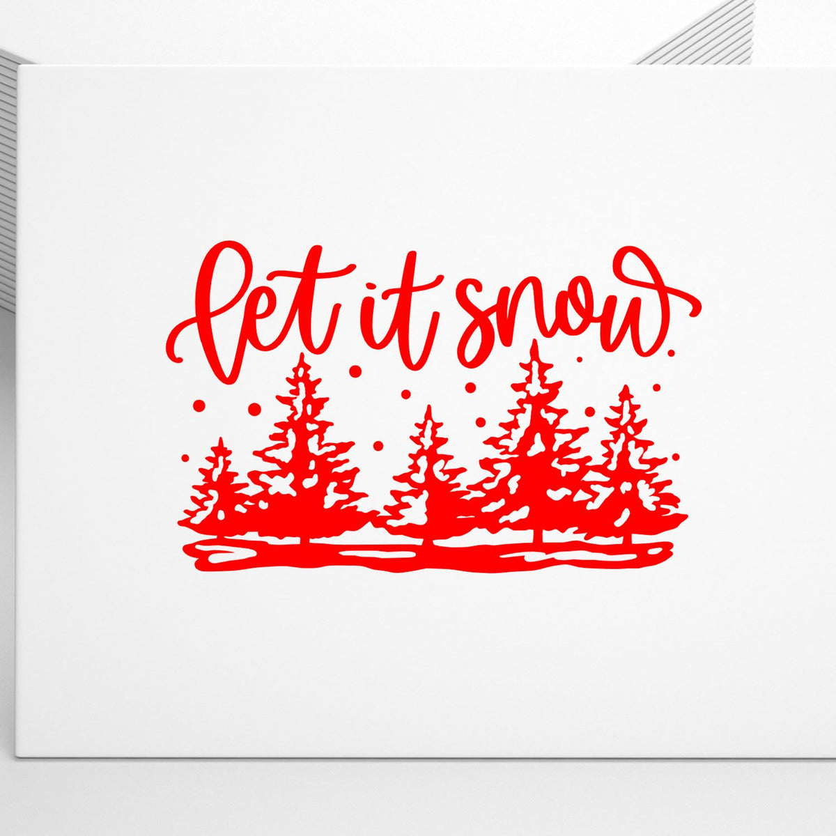 Red holiday stamp/seal with let it snow script, pine trees, and falling snow on a white background.