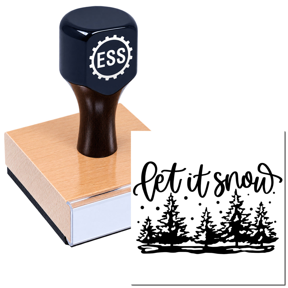 Black ESS rubber stamp on a wooden block, creating a black "Let it snow" seal with pine trees and snowflakes.