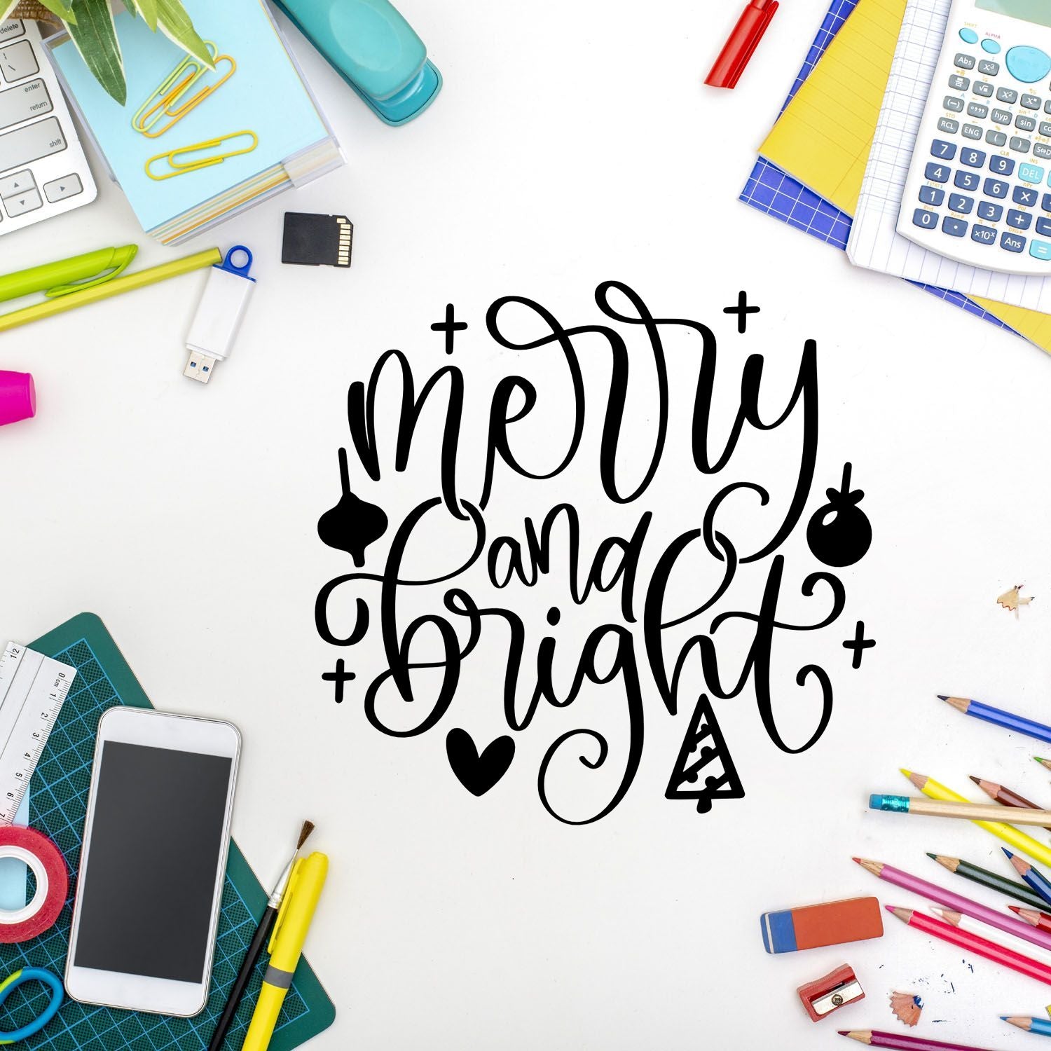 Black Merry and Bright stamp and seal design on white, surrounded by colorful stationery, pencils, calculator, and craft tools.