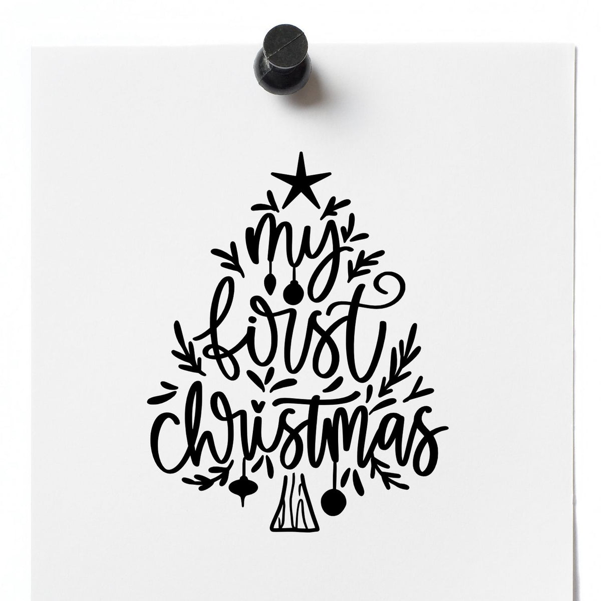 Black Christmas tree stamp and seal design with My First Christmas lettering on white paper.