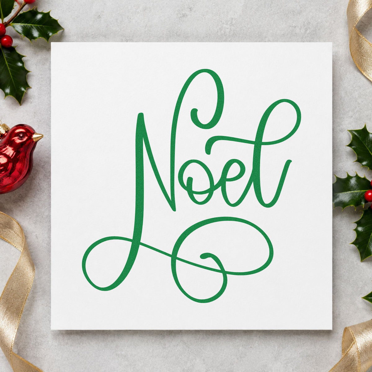 Noel Flowing Script craft stamp imprint in green ink on a handmade project, one idea being single word tags.