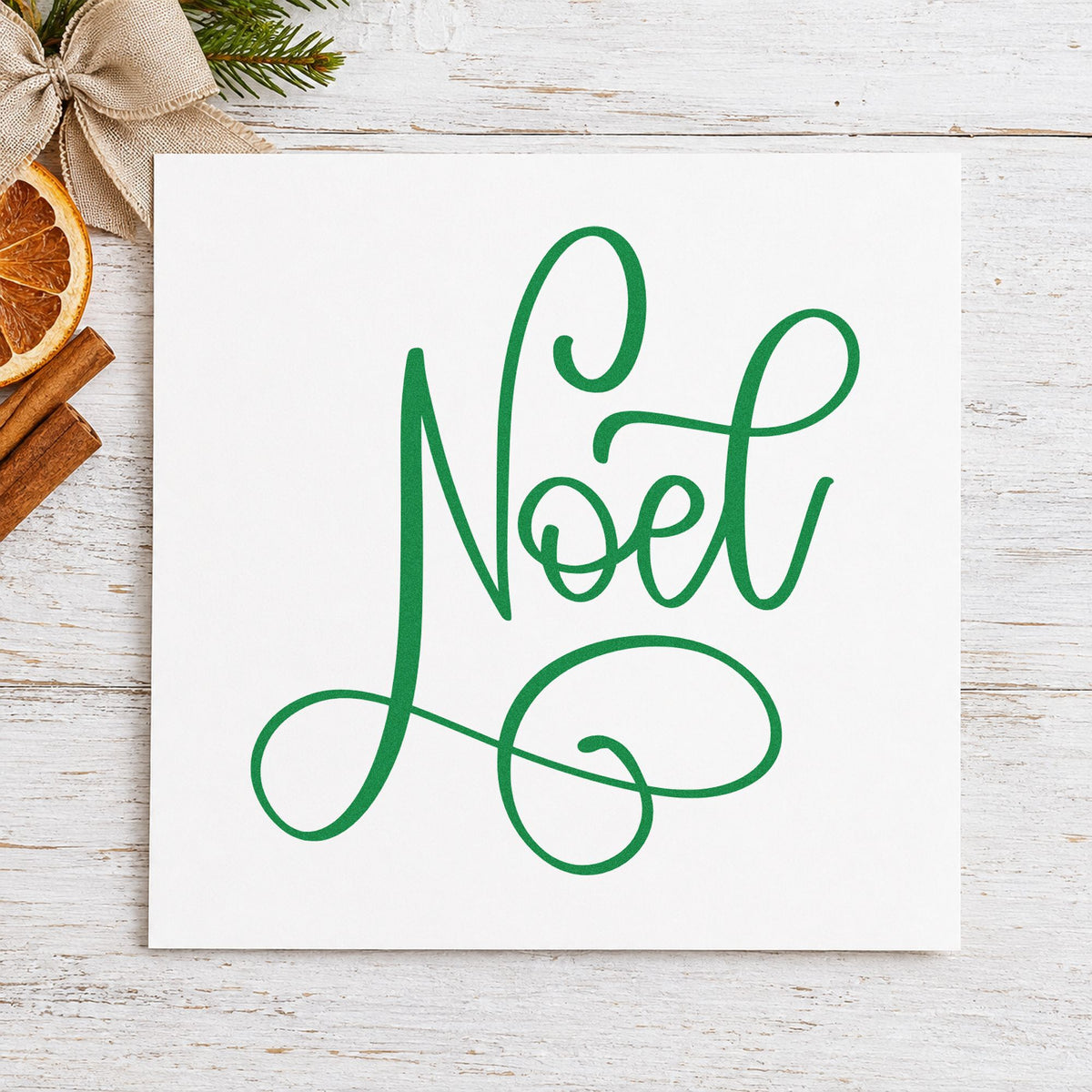 Noel Flowing Script craft stamp imprinted in green ink on paper, a design suited to framed mantel trio.
