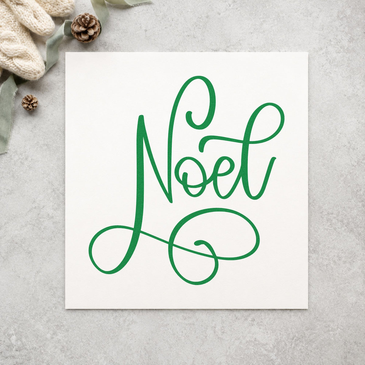 Noel Flowing Script craft stamp imprint in green ink on a handmade project, one idea being reception sign boards.