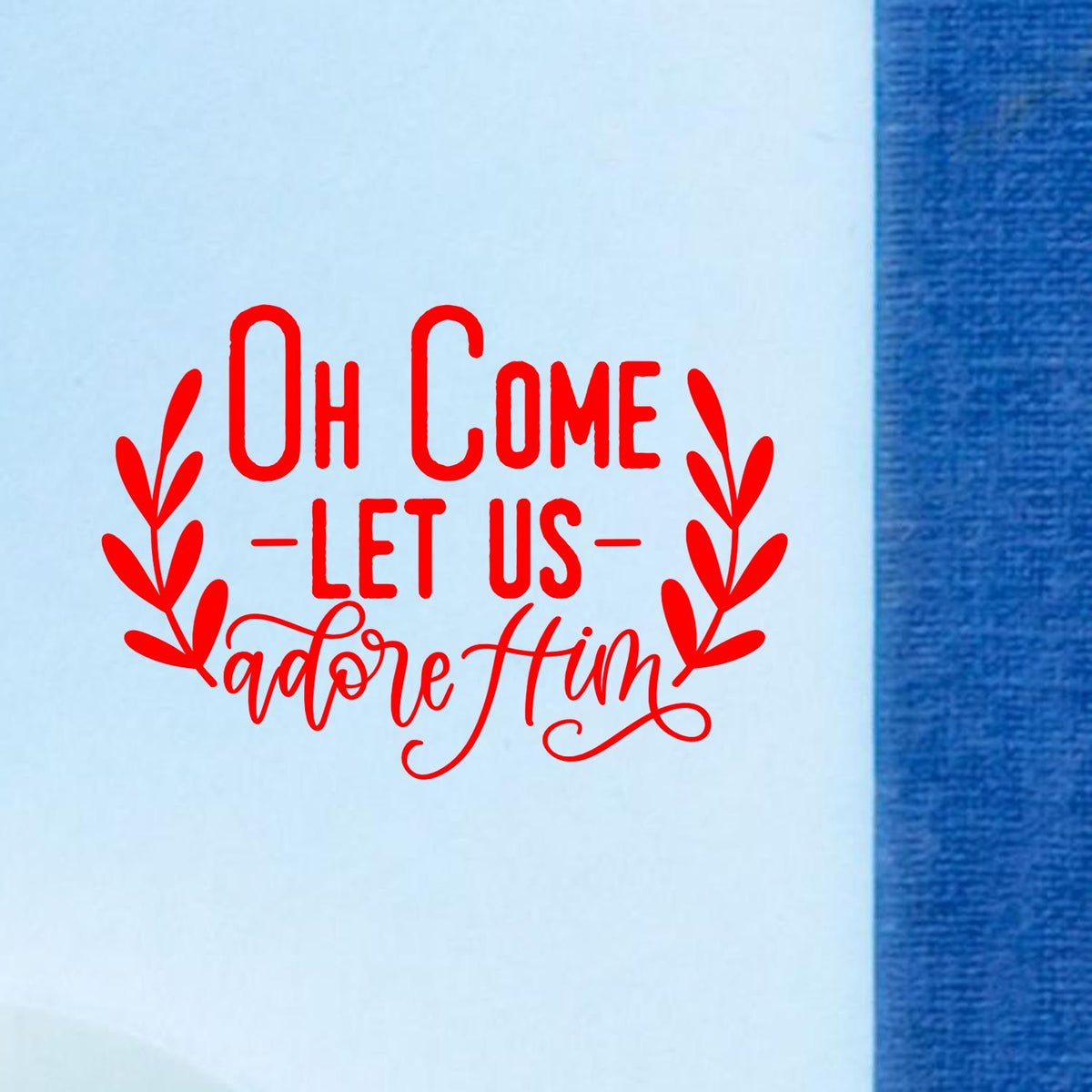 Red decorative stamp seal reading Oh Come Let Us Adore Him on light blue background with blue border.