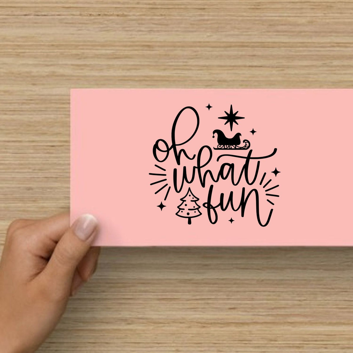 Pink stamp and seal product with black oh what fun lettering, sleigh, Christmas tree, and star accents.