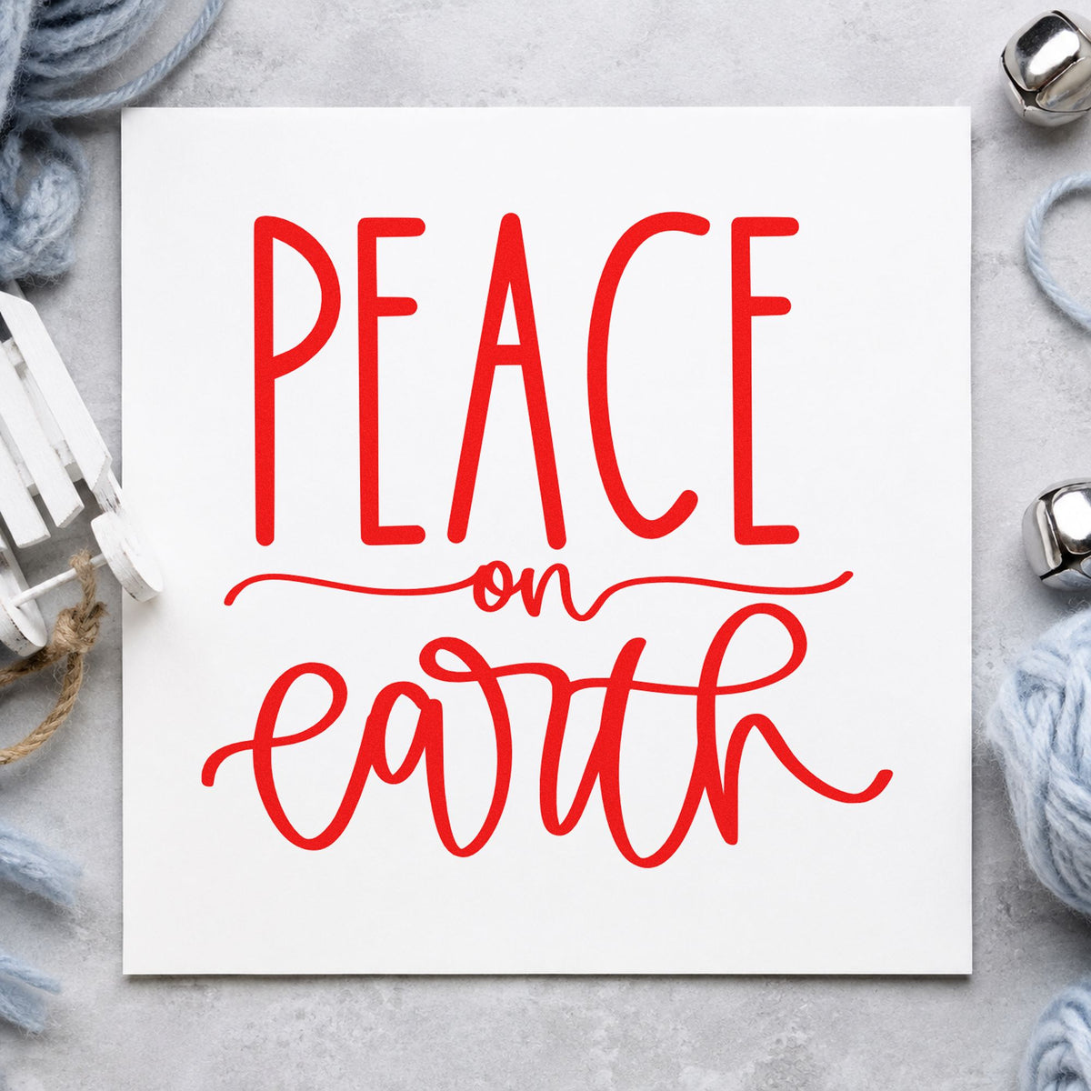 Peace On Earth Script craft stamp in red ink on cardstock, an easy option for yoga mat bag ink.