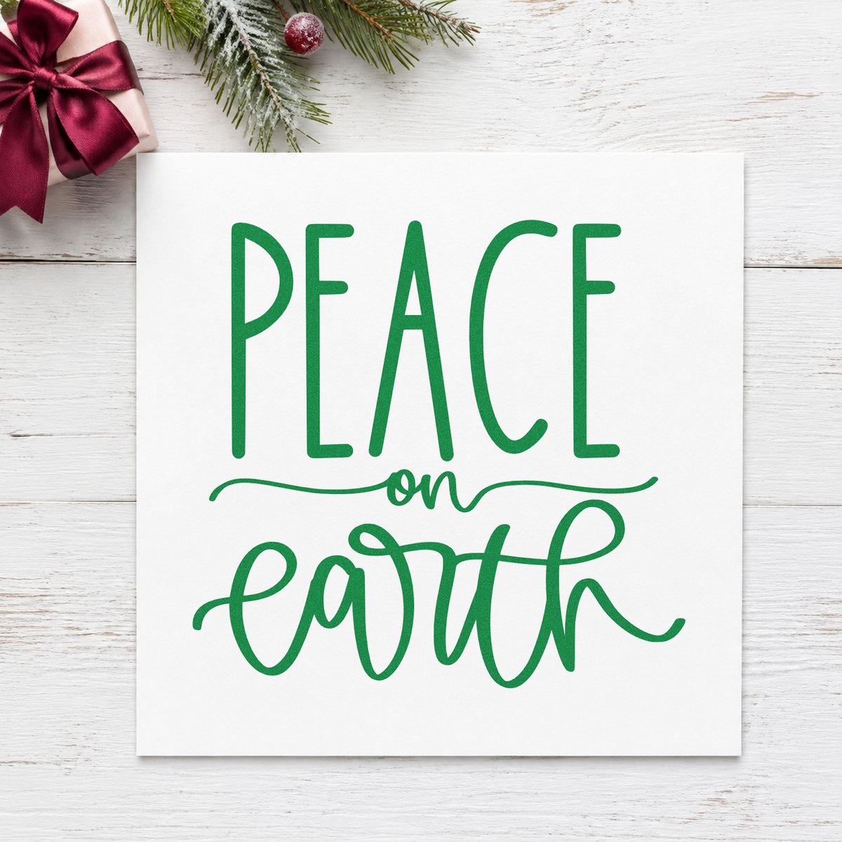Peace On Earth Script craft stamp imprint in green ink on a handmade project, one idea being retreat welcome cards.
