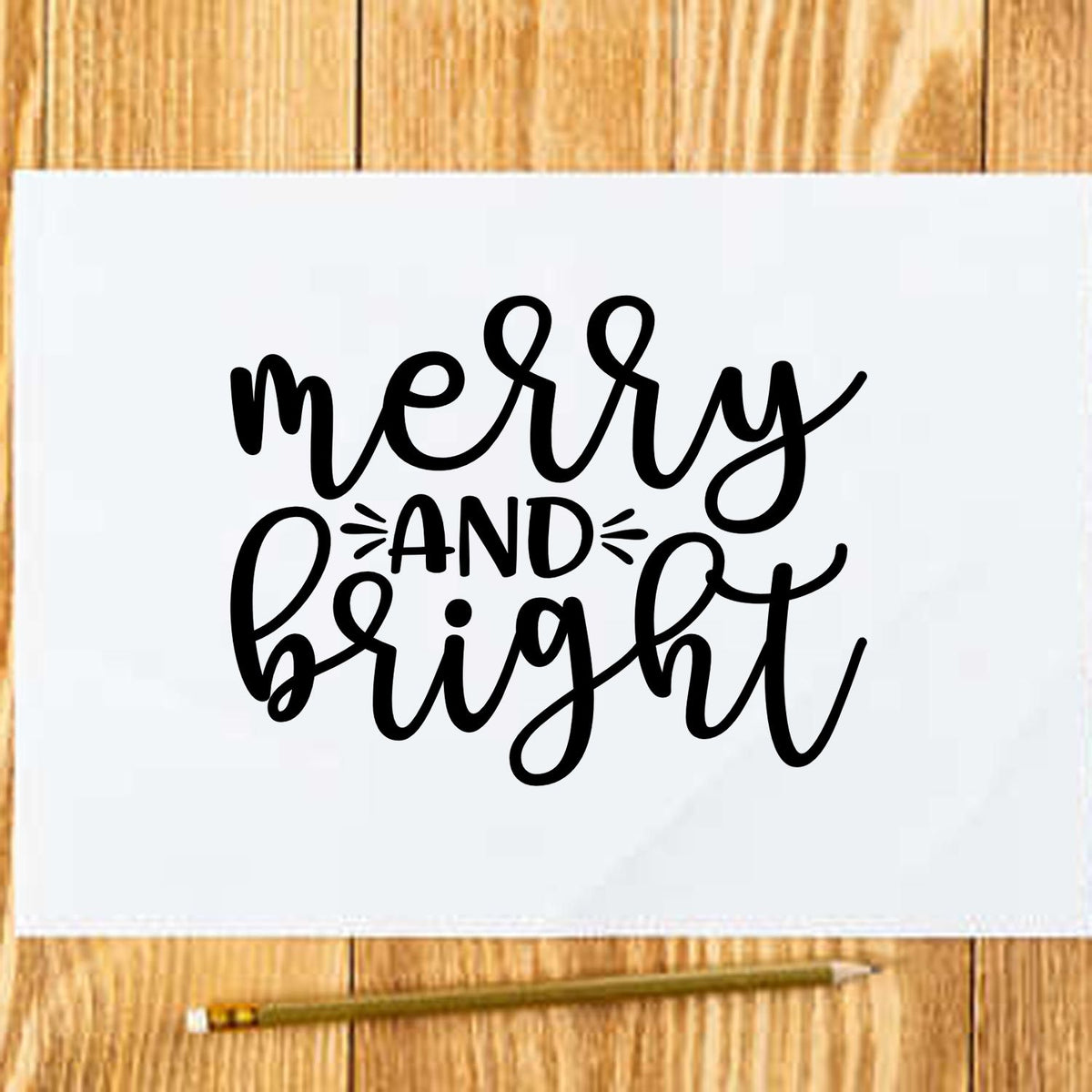 Black merry and bright stamp and seal design on white paper over wood, with pencil.