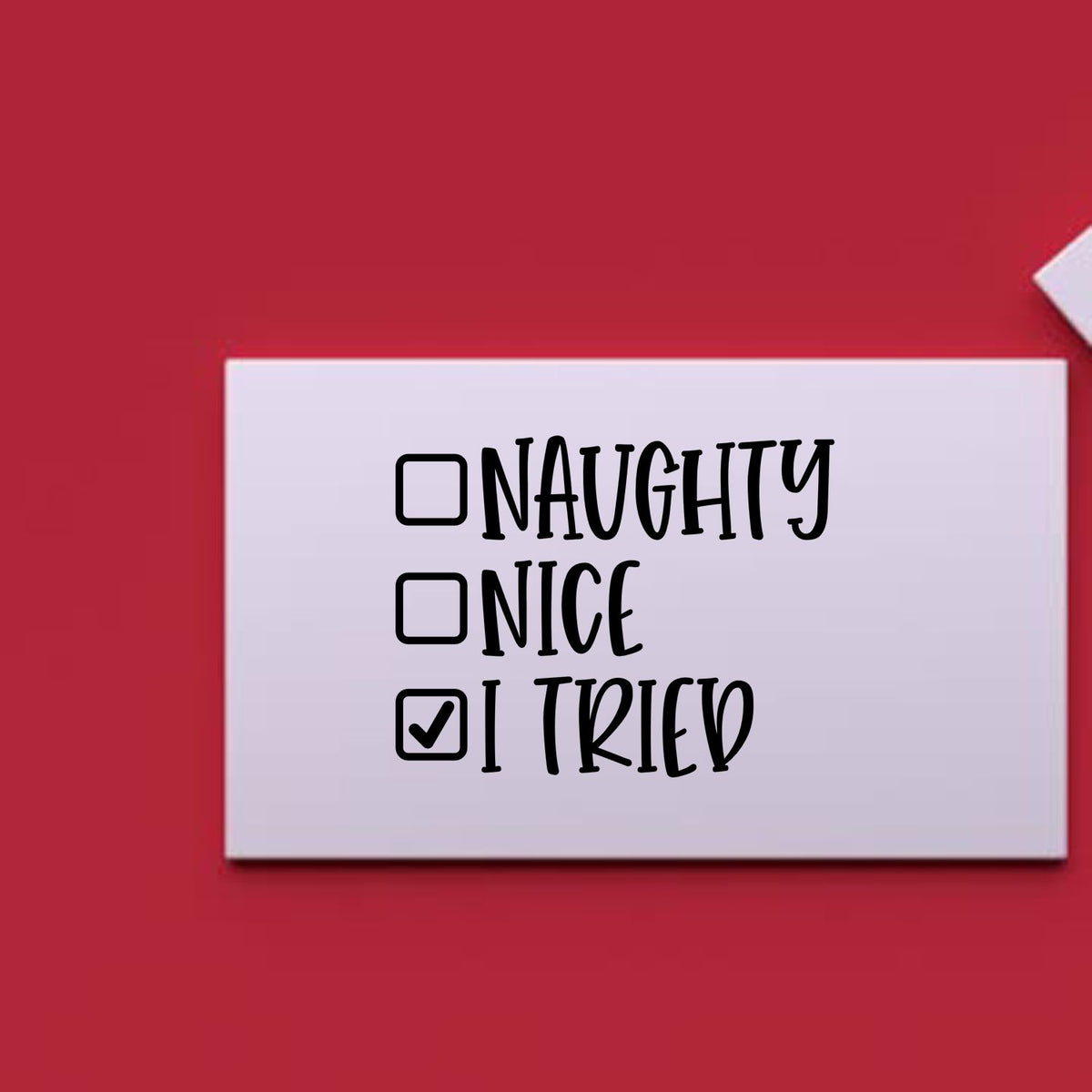 White stamp seal card on red background with checklist reading Naughty, Nice, I Tried; I Tried is checked.