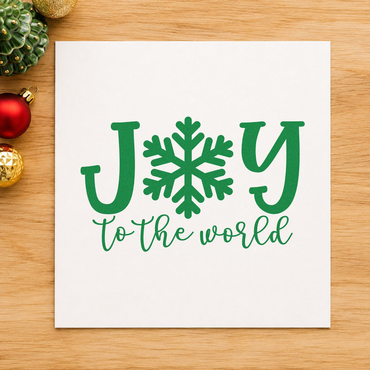 Joy World Snowflake Letter craft stamp imprinted in green ink on paper, a design suited to framed winter window.