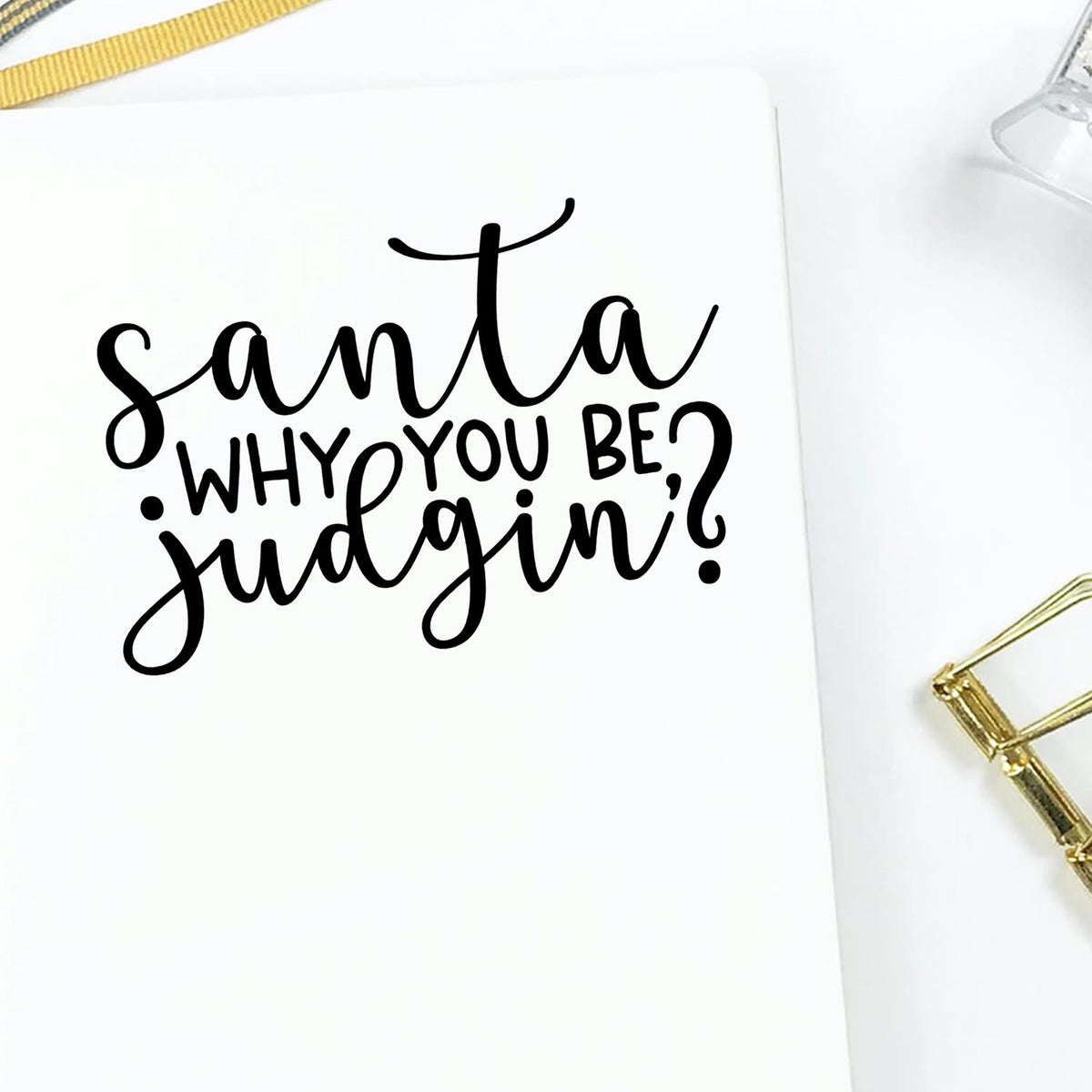 Custom stamp and seal with black script Santa why you bein judgin? on white card, accented by gold ribbon and clip.