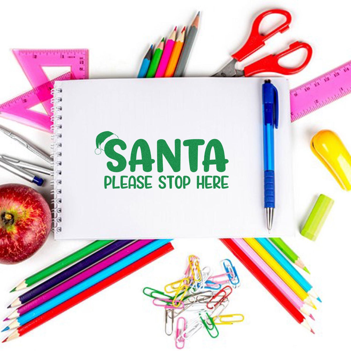 Green Santa stamp seal with SANTA PLEASE STOP HERE, surrounded by colorful pencils, rulers, pens, and scissors.