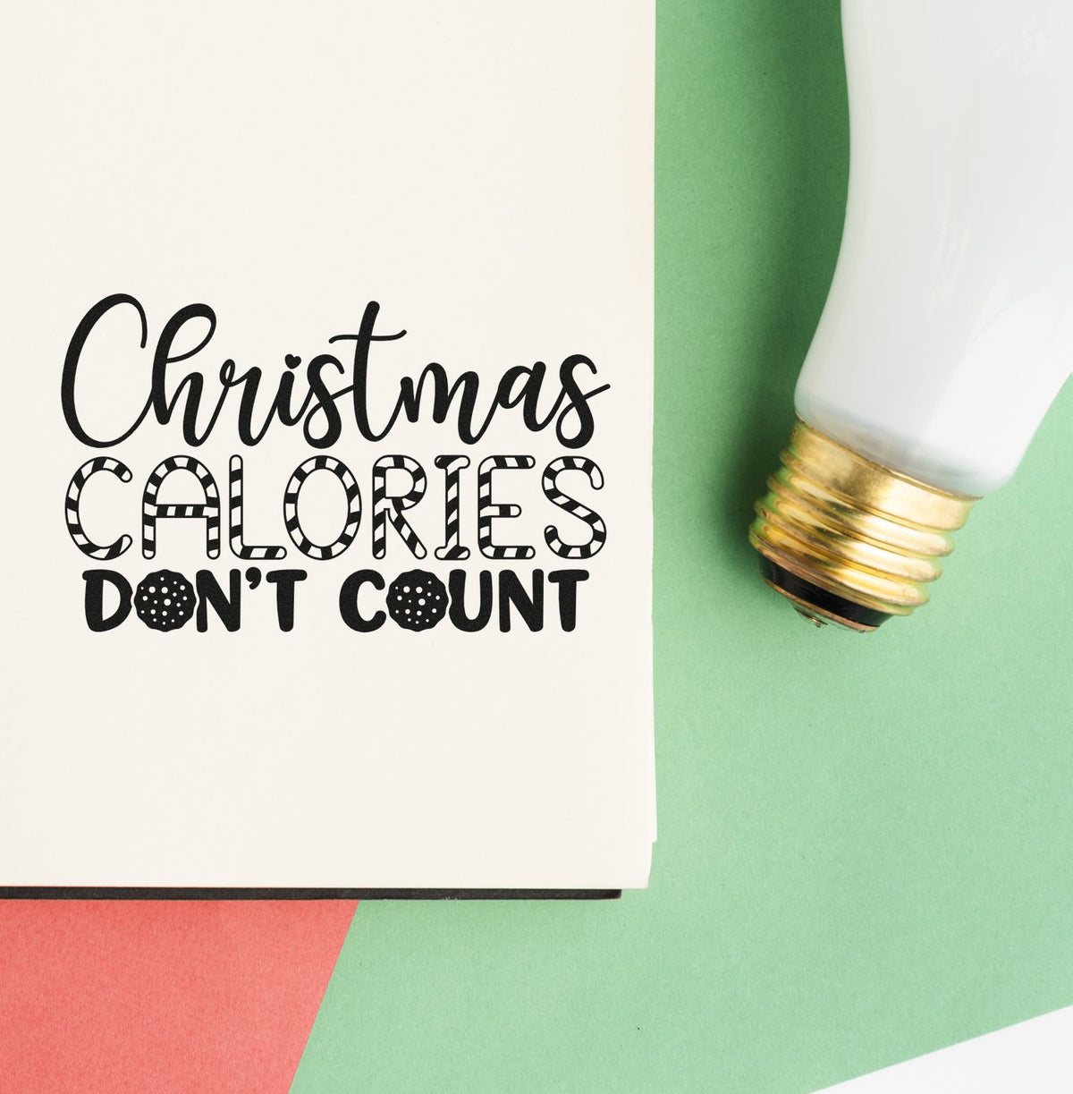 Christmas Calories Dont Count stamp and seal with white handle, gold ferrule, on white card over green and coral background