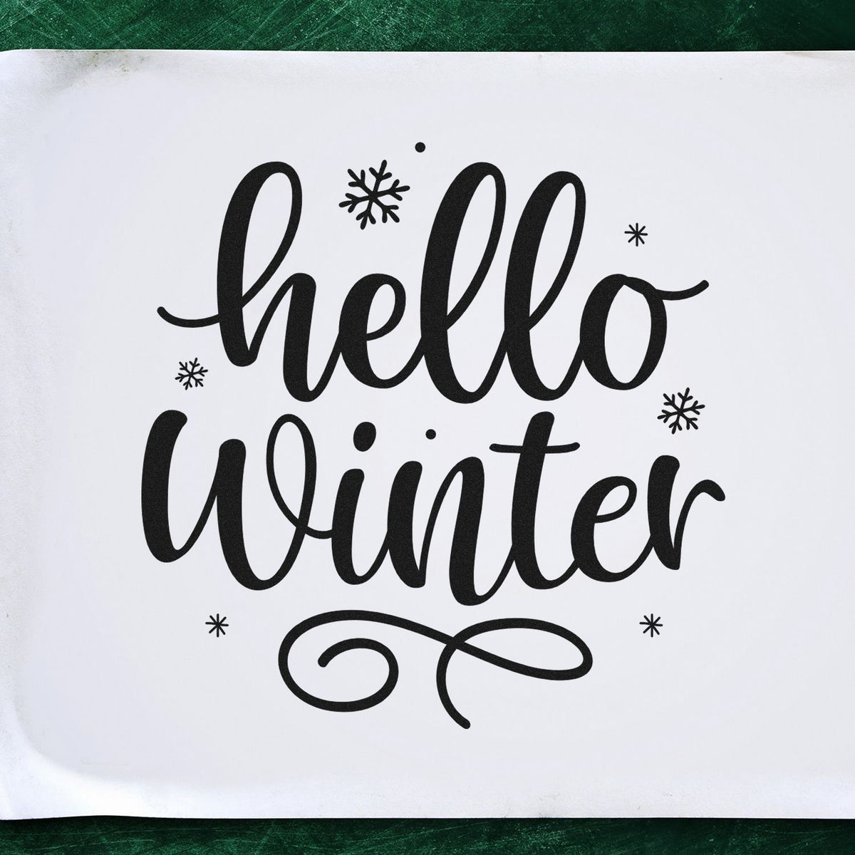 Black hello winter stamp and seal design with snowflakes on a white background, featuring bold decorative script.