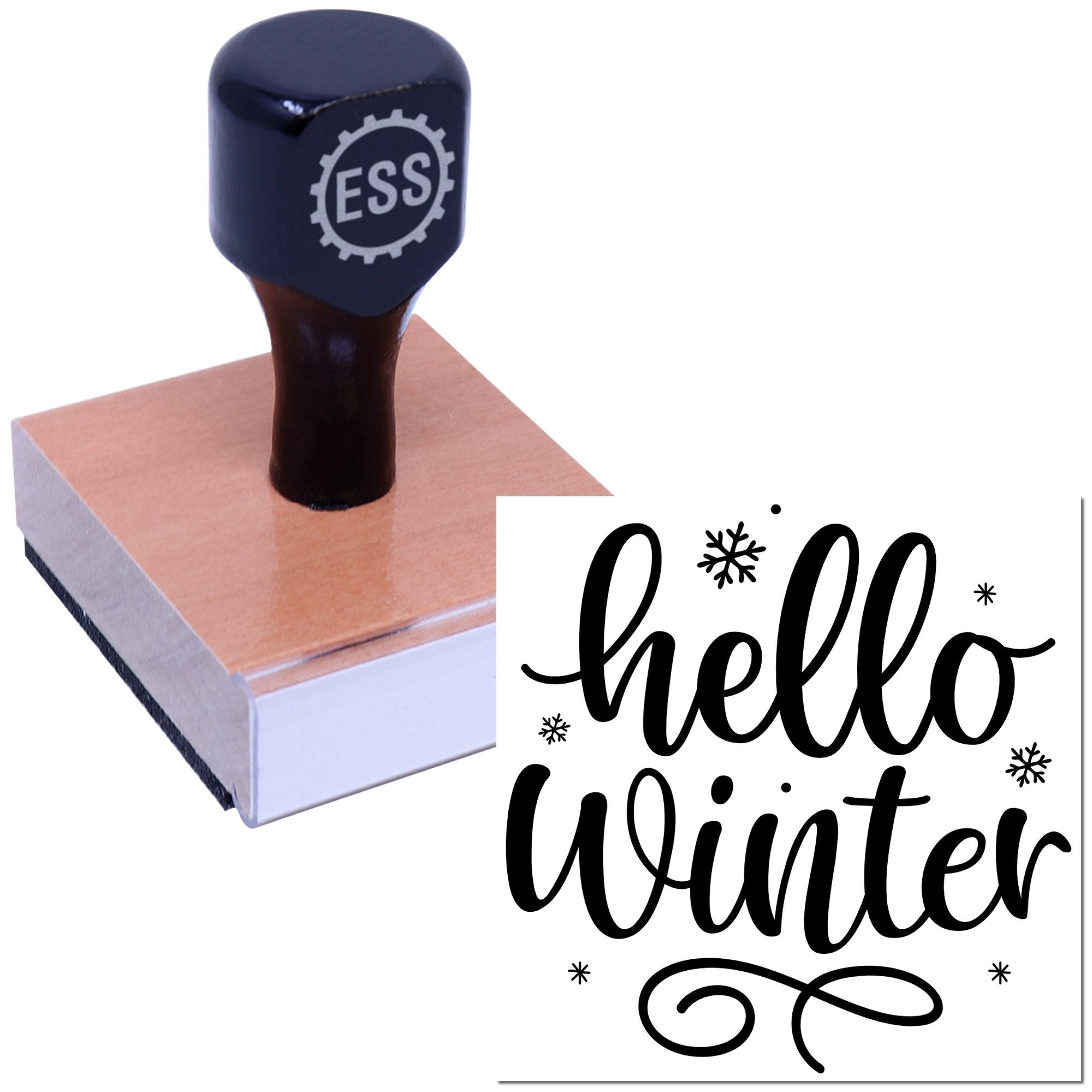 Dark navy rubber stamp and seal on wood block, stamping hello winter in black script with snowflakes.
