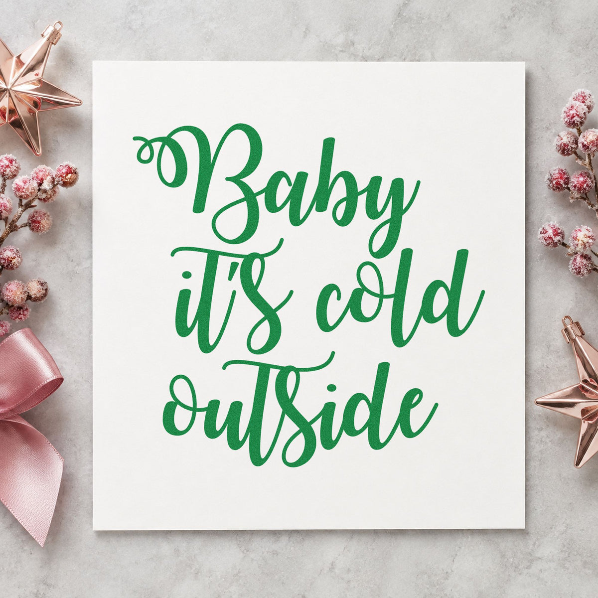 Baby It's Cold Outside Script craft stamp imprint in green ink on a handmade project, one idea being firewood bundle tags.