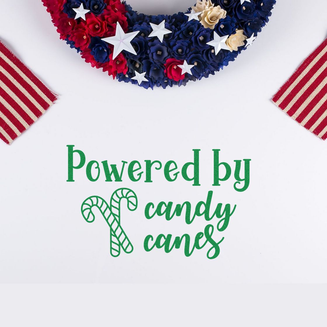 Green holiday stamp and seal reading Powered by candy canes with candy cane graphic, red-blue floral wreath and striped corners.