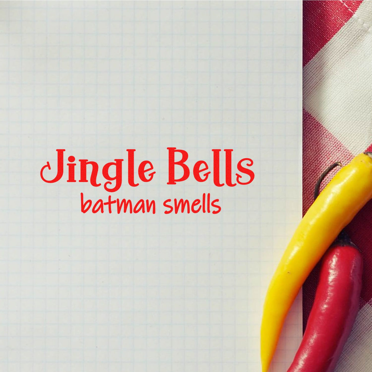 Red holiday stamp and seal design reading Jingle Bells batman smells on graph paper, with red, white and yellow handles.