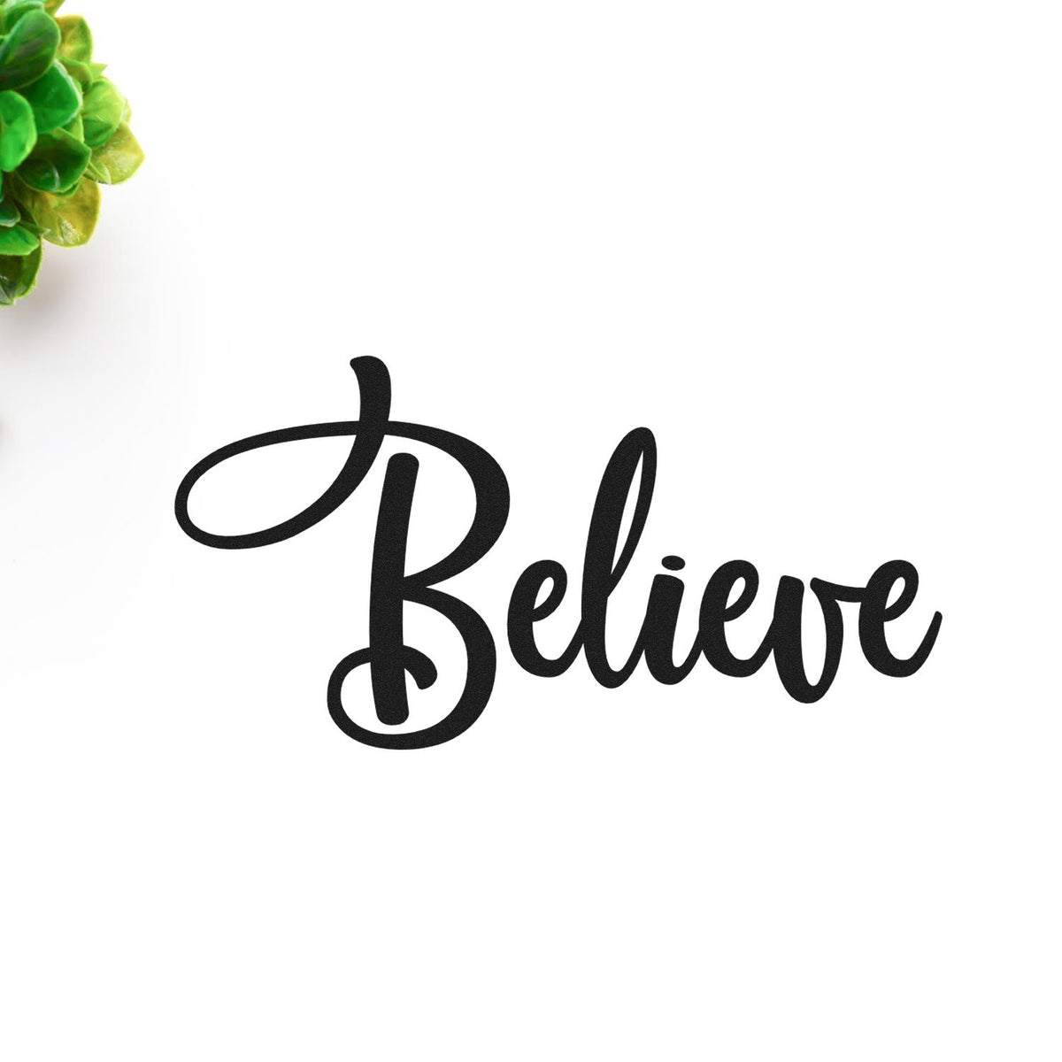 Black Believe script stamp and seal design on white with green leaves in the corner