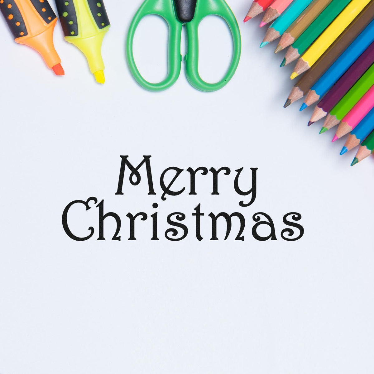 Merry Christmas seal stamp in black script, framed by colorful pencils, markers, and green scissors on white background.