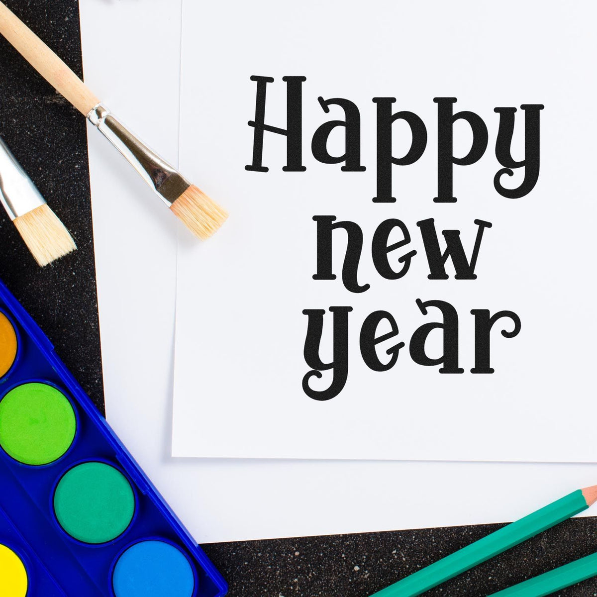 Happy New Year stamp and seal design on white paper, with paintbrushes and a bright watercolor palette.