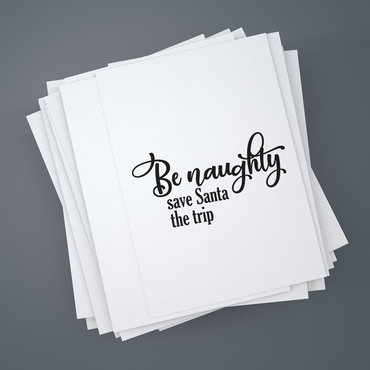White custom stamp and seal sheets with black Be naughty, save Santa the trip lettering on a gray background.