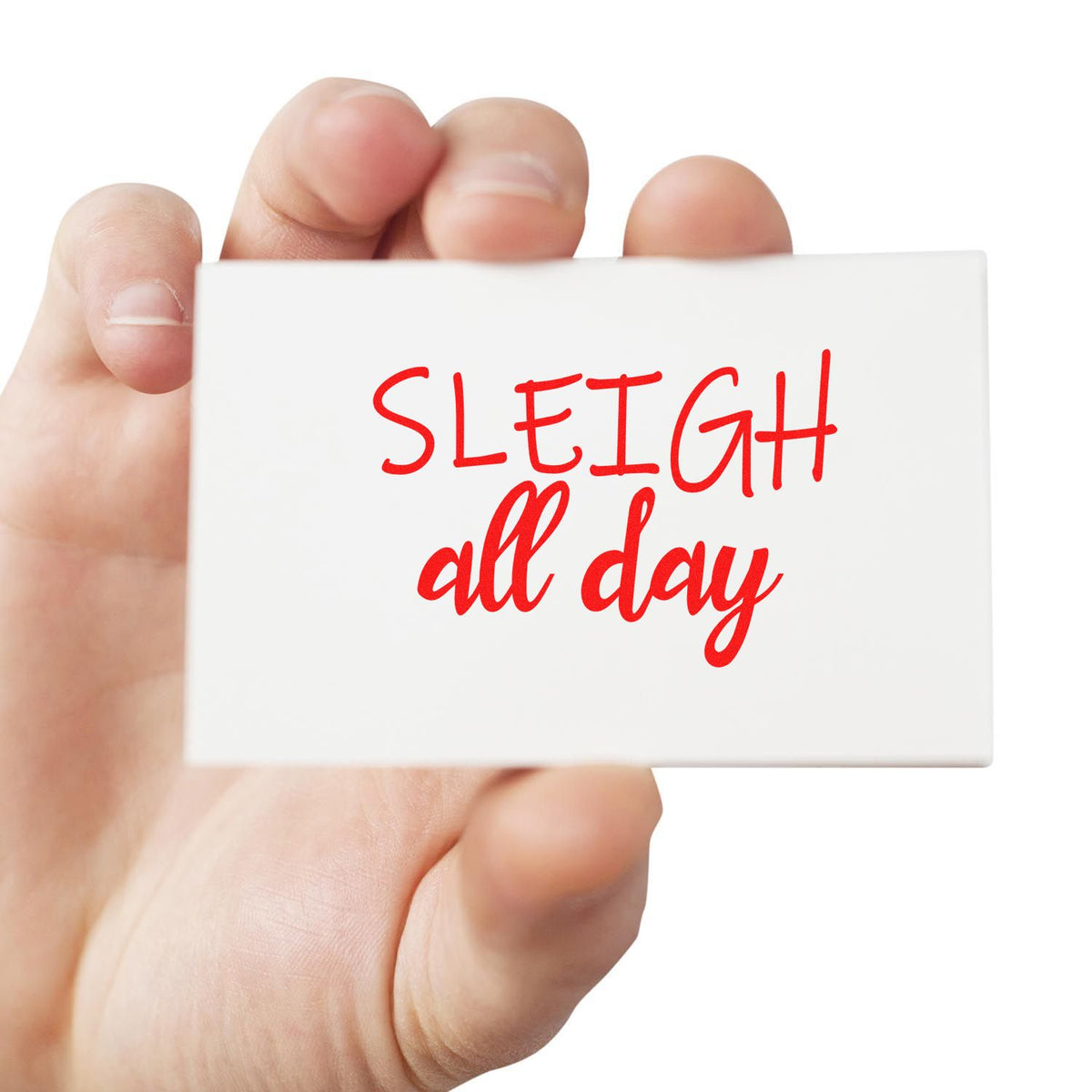 Hand holding white custom stamp seal with red SLEIGH all day text on a clean background.