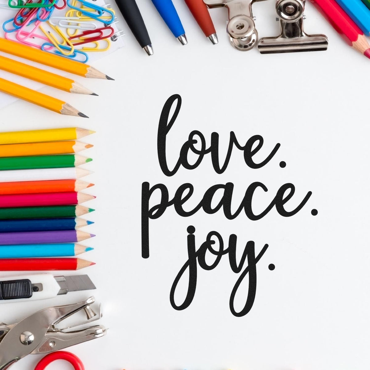 Black love, peace, joy stamp and seal design with colorful pencils, paper clips, binder clips, and craft tools.