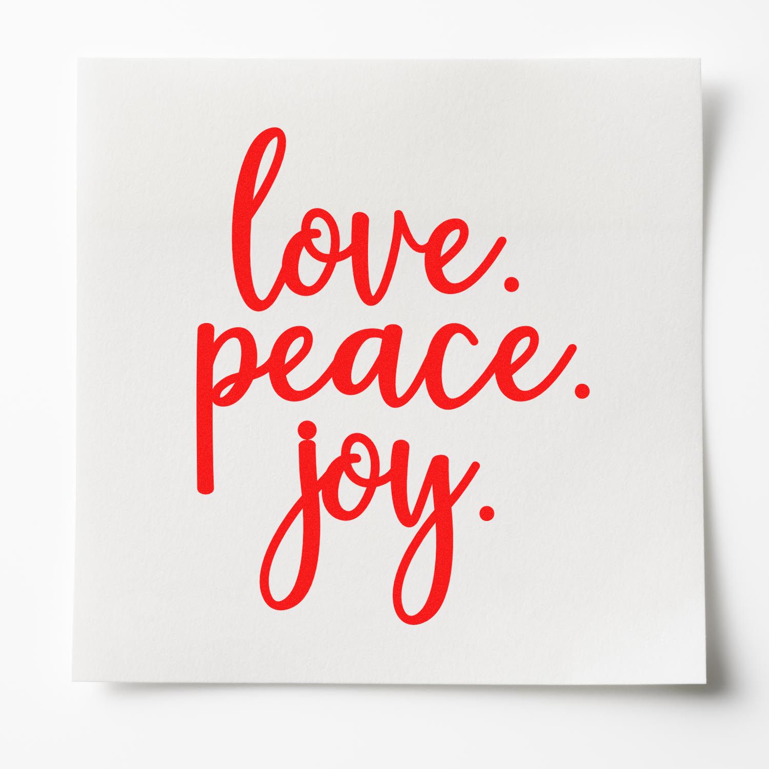 Bright red love, peace, joy script stamp on white card, showcasing a custom seal product.