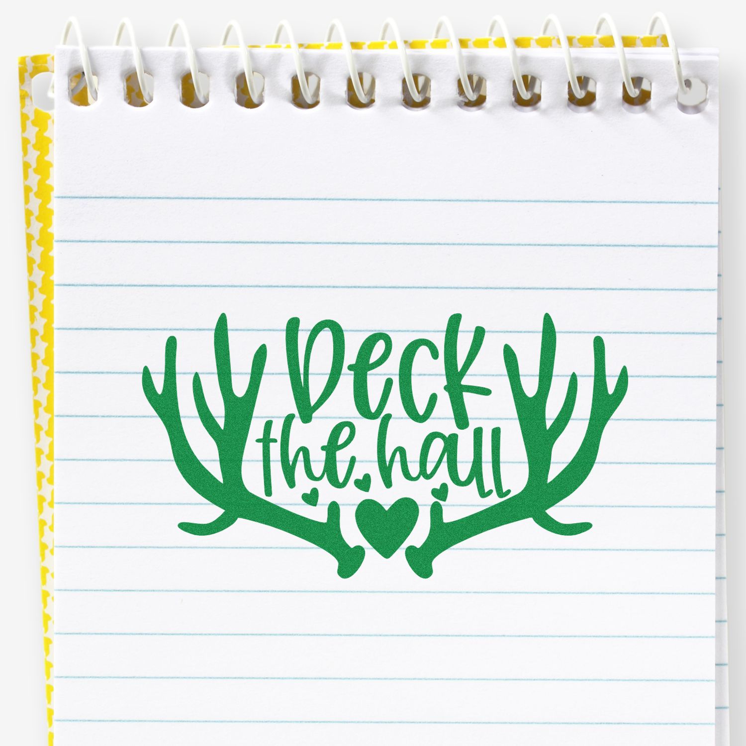 Green deer the hall holiday stamp with antlers and heart on lined spiral notebook, yellow patterned edge.