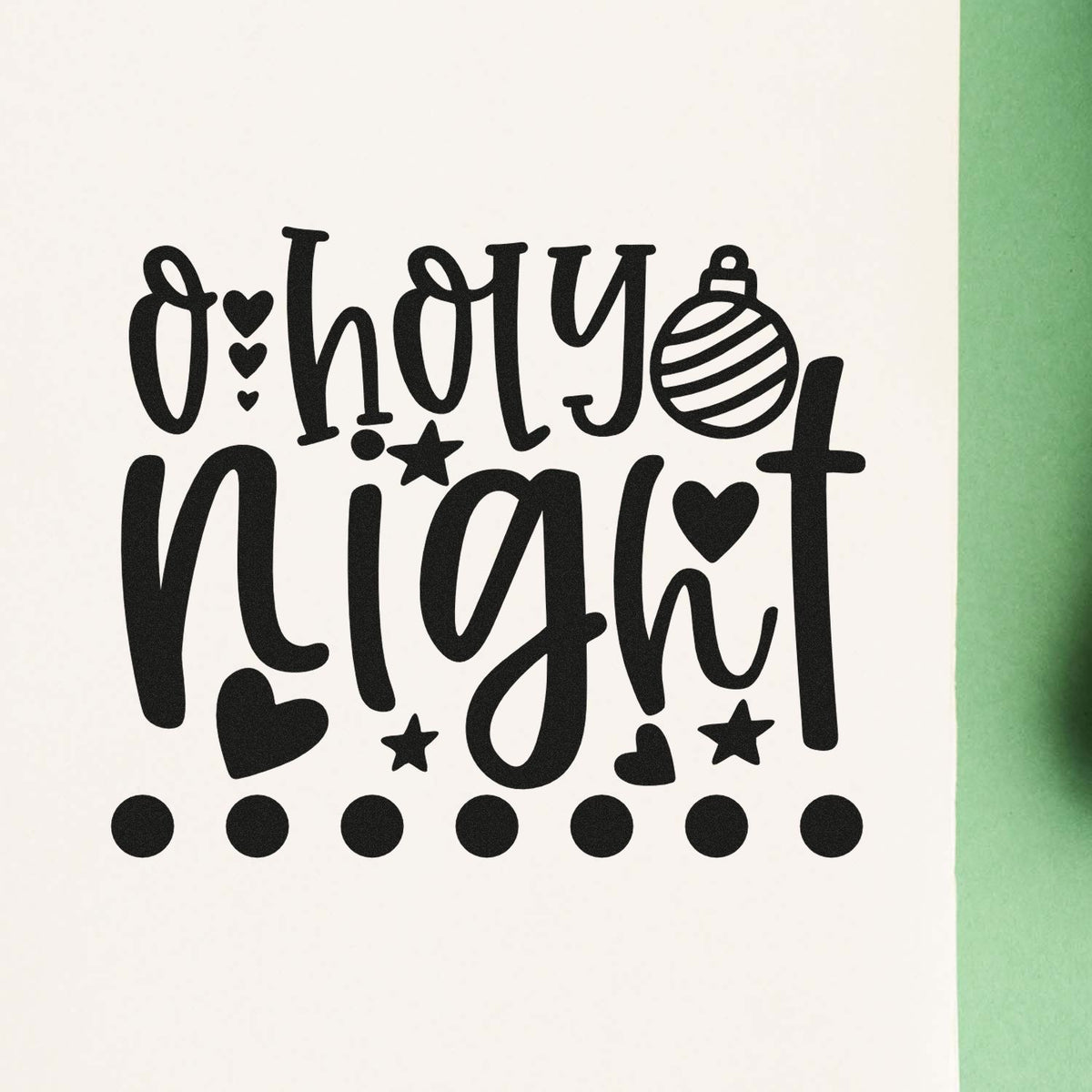 Black Oh Holy Night stamp and seal design with hearts, stars, ornament and dots on a white background with green edge.