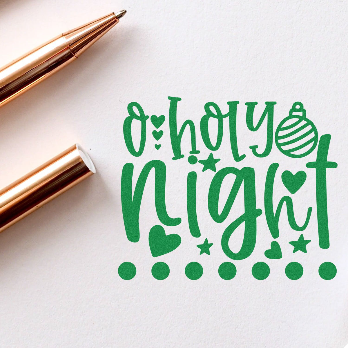 Rose gold stamp and seal tools beside green oh happy night holiday design with hearts, stars, ornament, and dots.