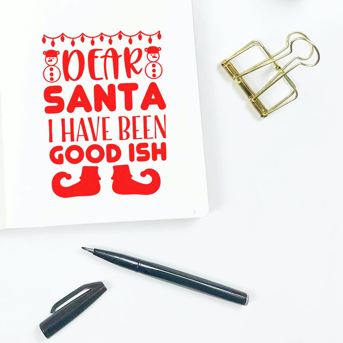 Red Christmas stamp reading Dear Santa I have been good ish with snowmen, elf boots, gold clip seal, and black pen.