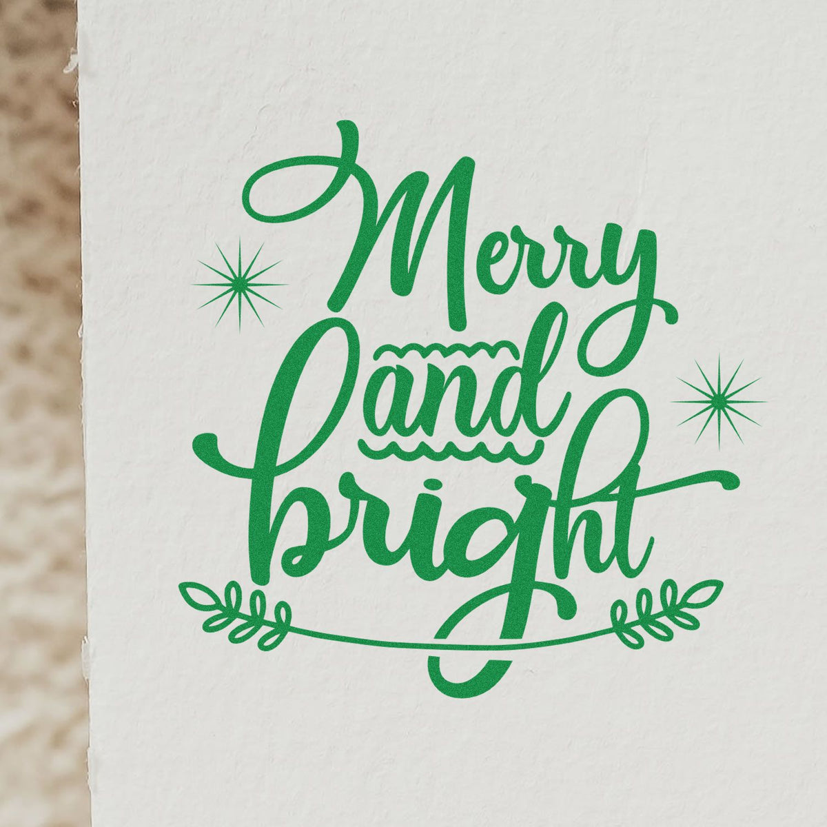 Green Merry and Bright holiday stamp seal with starbursts and leafy accents on white paper.