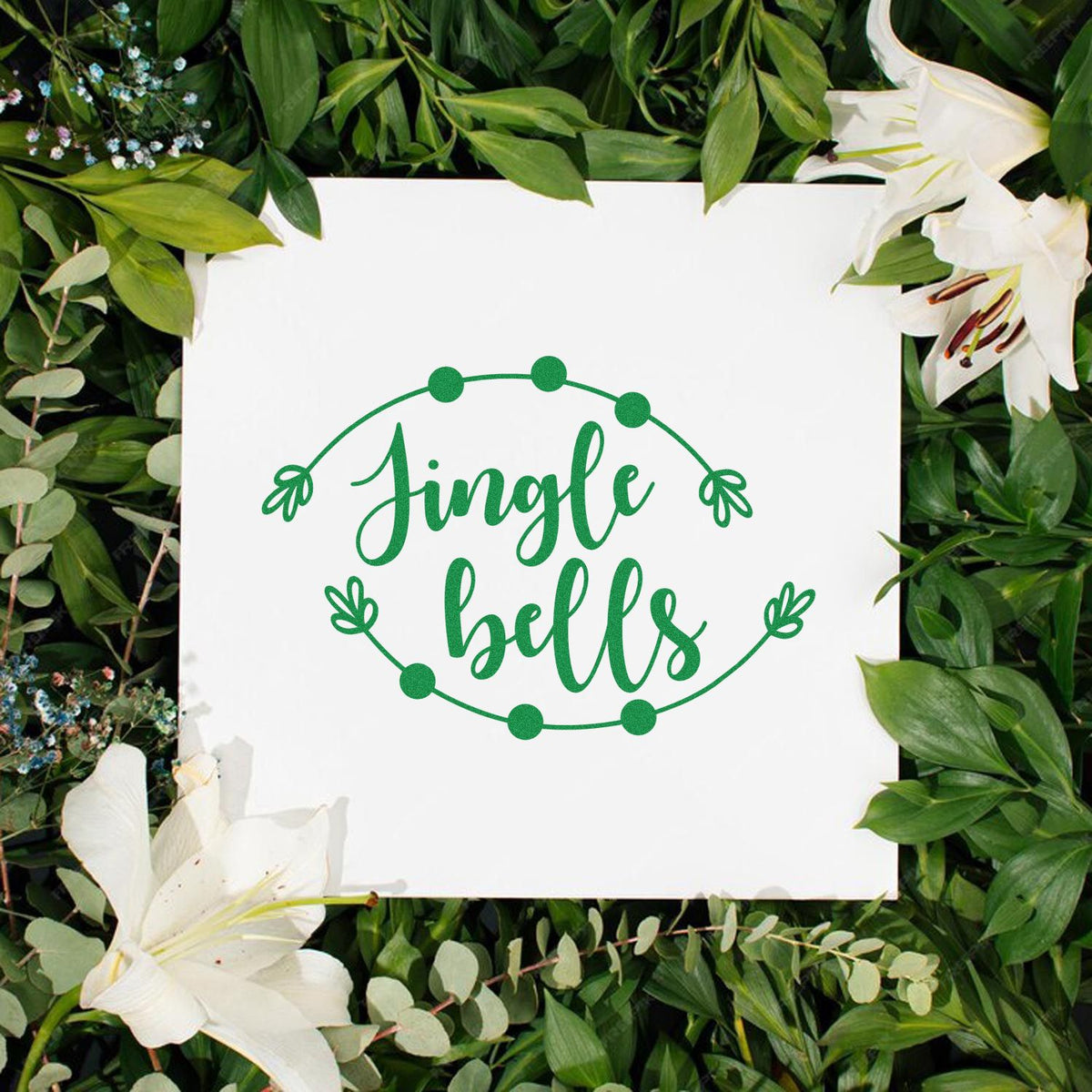 Green Jingle Bells stamp and seal design on white, with a floral wreath and green leaves, framed by white lilies.