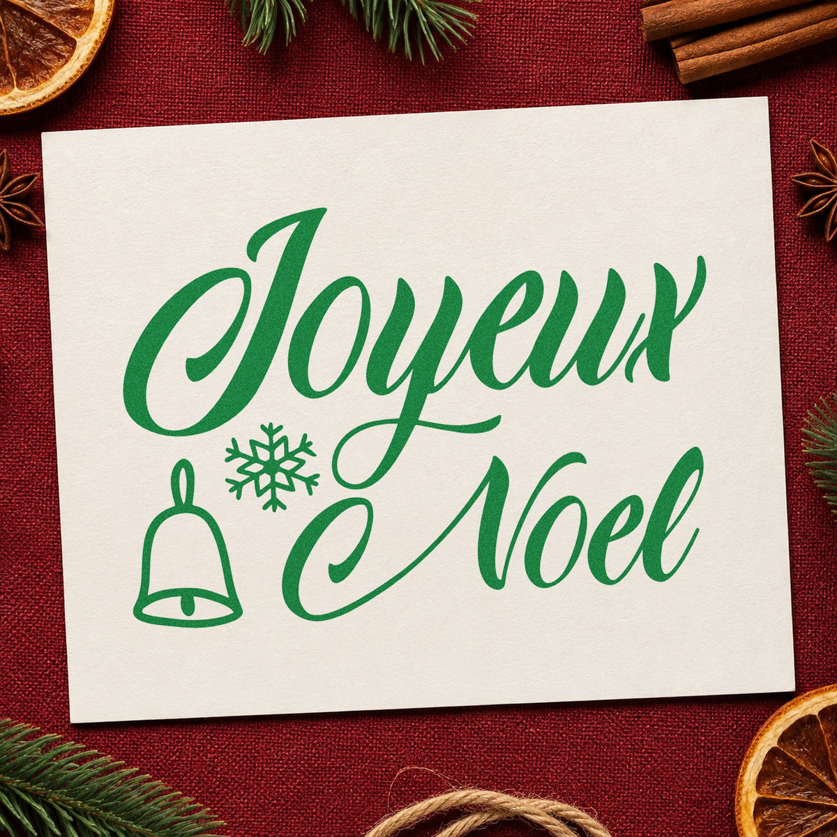 Joyeux Noel Bell Snowflake craft stamp imprint in green ink on a handmade project, one idea being patisserie box tags.