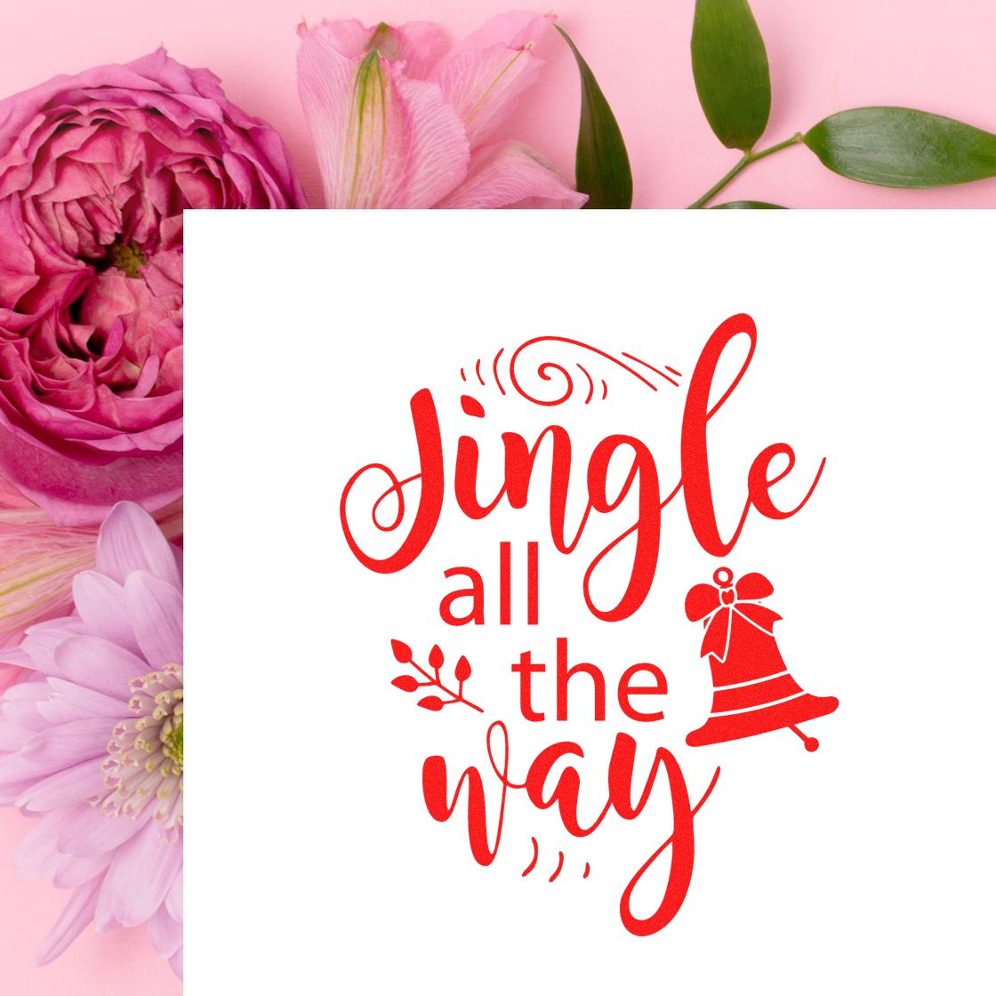 Red Jingle all the way holiday stamp/seal with bell on white card, set against pink flowers.