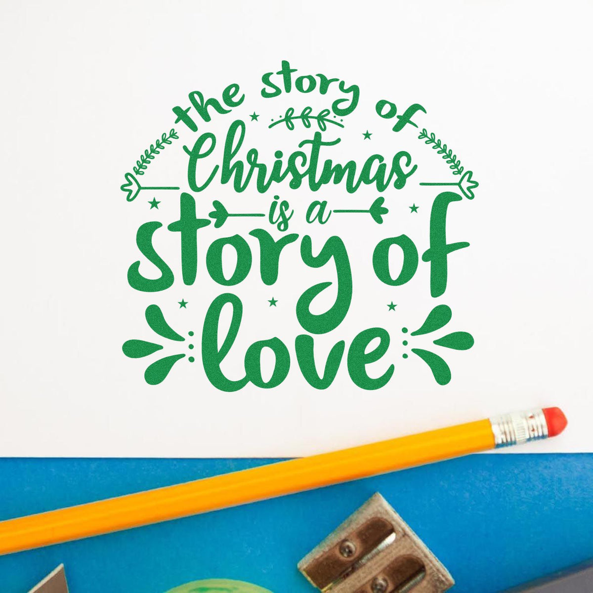 Green Christmas stamp seal with leafy accents and quote, the story of Christmas is a story of love, on white paper.