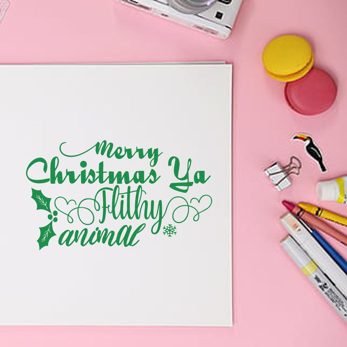 Green Merry Christmas Ya Filthy Animal stamp on white card, with pink background, seal pads, and markers