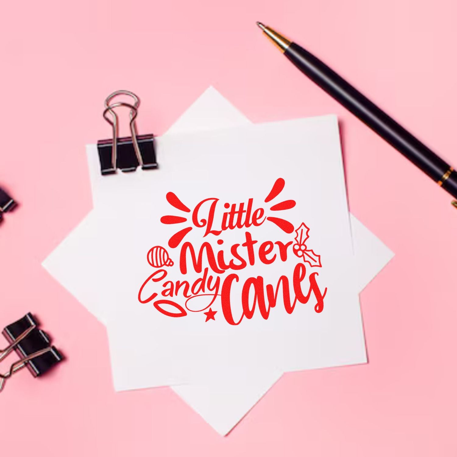 Red Little Mister Candy Canes stamp and seal design on white paper, with black pen and binder clips on a pink background.