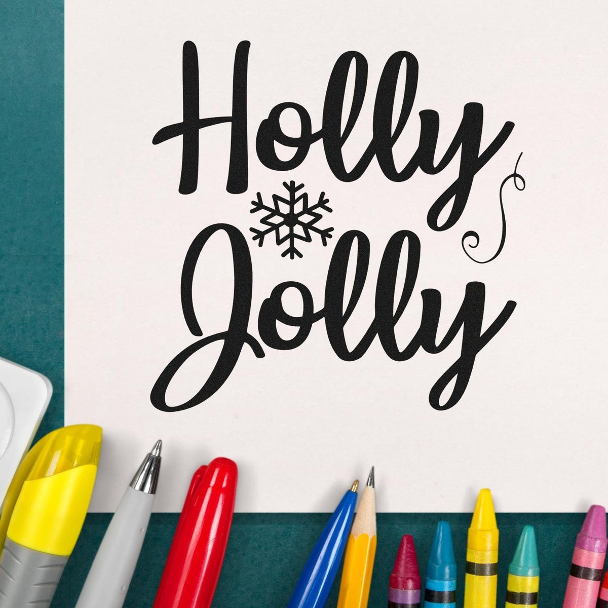 Black Holly Jolly stamp and seal design with snowflake on white paper, surrounded by colorful markers.