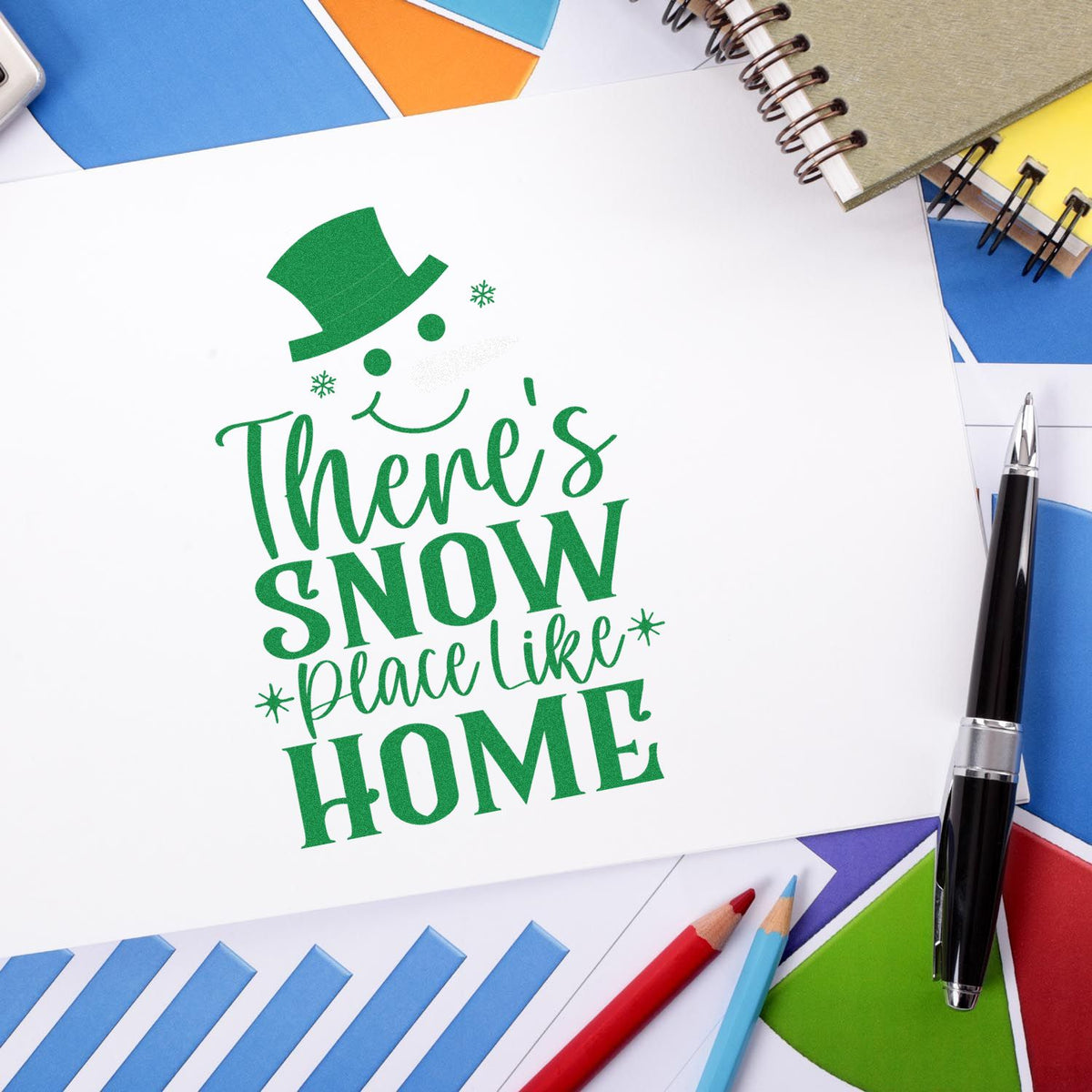 Green holiday rubber stamp and seal design reading Theres Snow Place Like Home with top hat, snowflakes, and stationery.