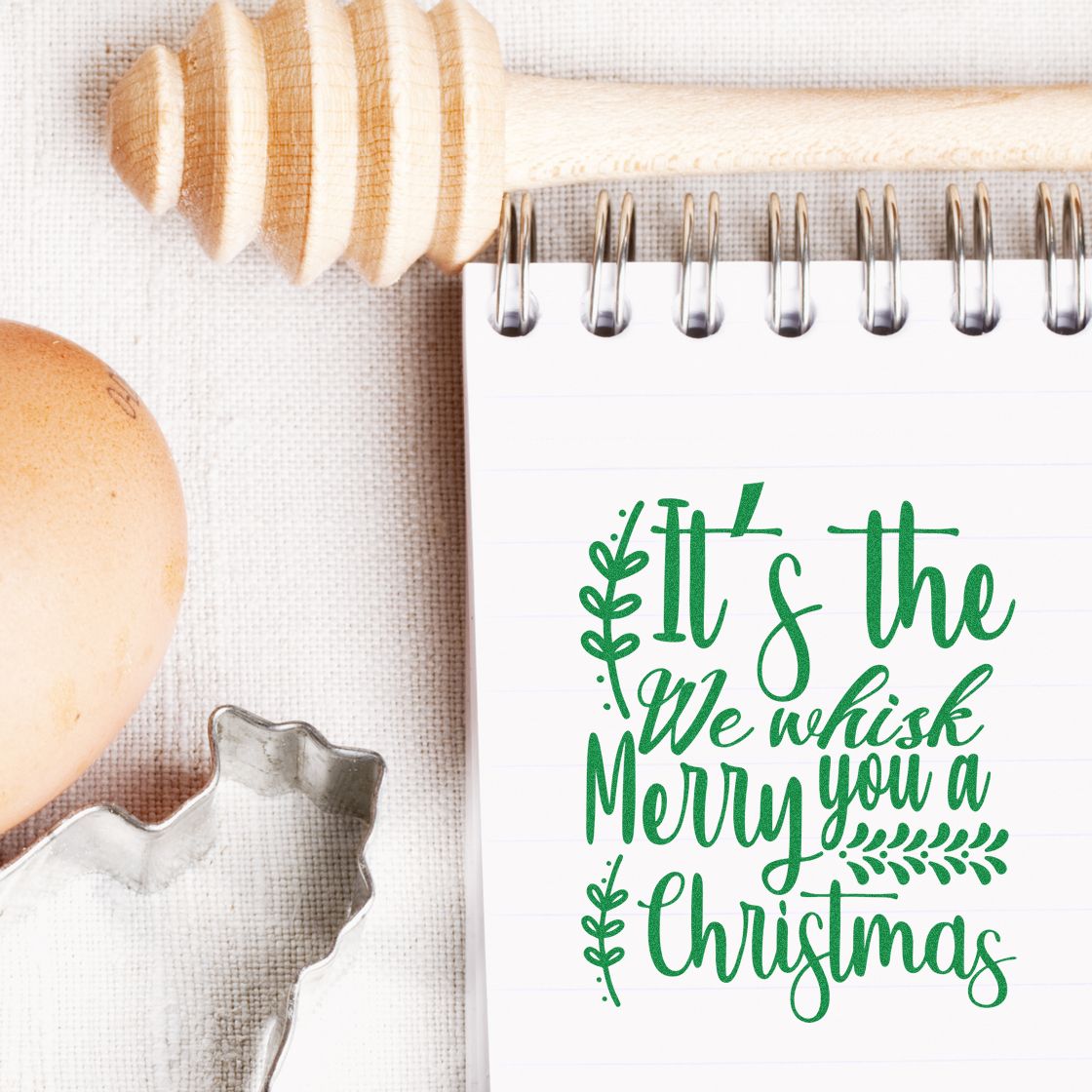 Green Merry Christmas stamp and seal on notepad, with wooden stamp handle and silver cutter.