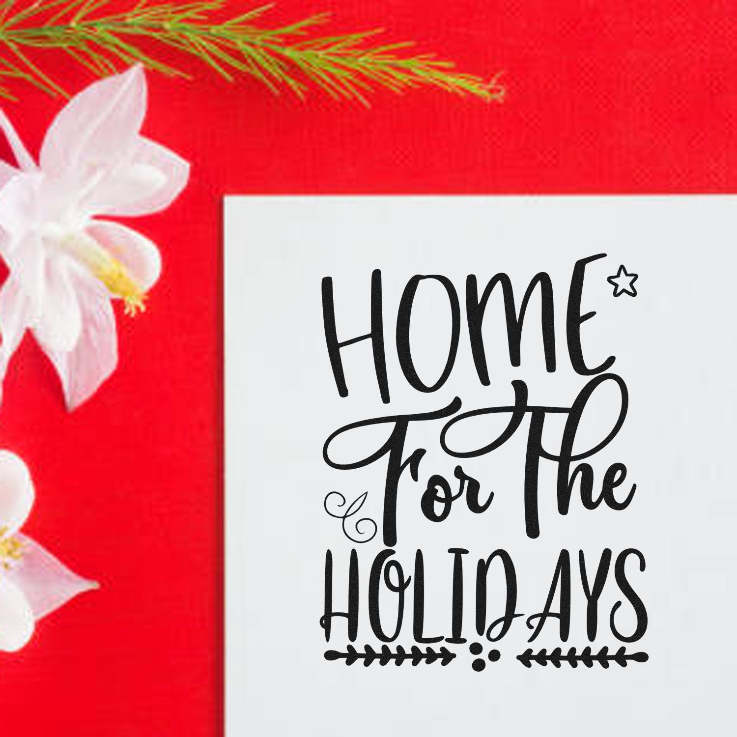 Home for the Holidays stamp and seal on white card, black lettering on bright red background with white flowers and greenery