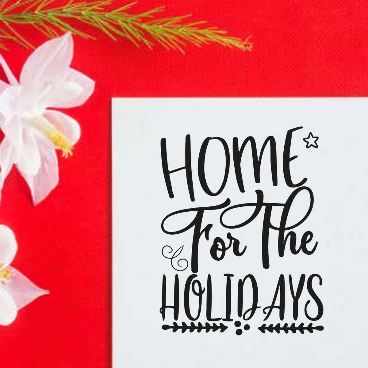 White stamp and seal with black Home for the Holidays lettering on a bright red background with white flowers.