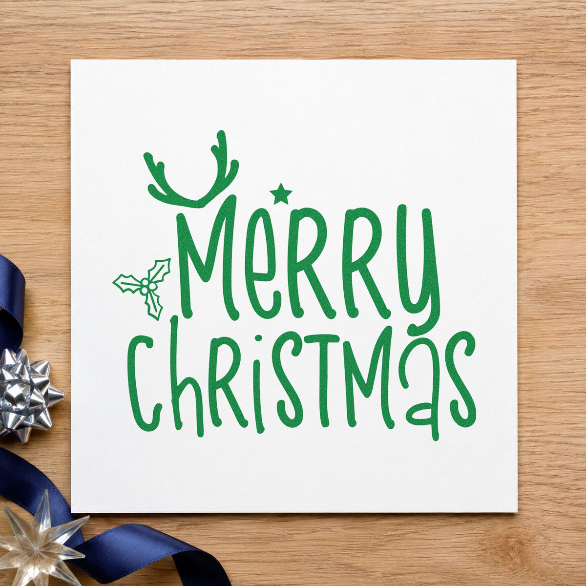 Merry Christmas Antlers Holly craft stamp imprint in green ink on a handmade project, one idea being guest place cards.