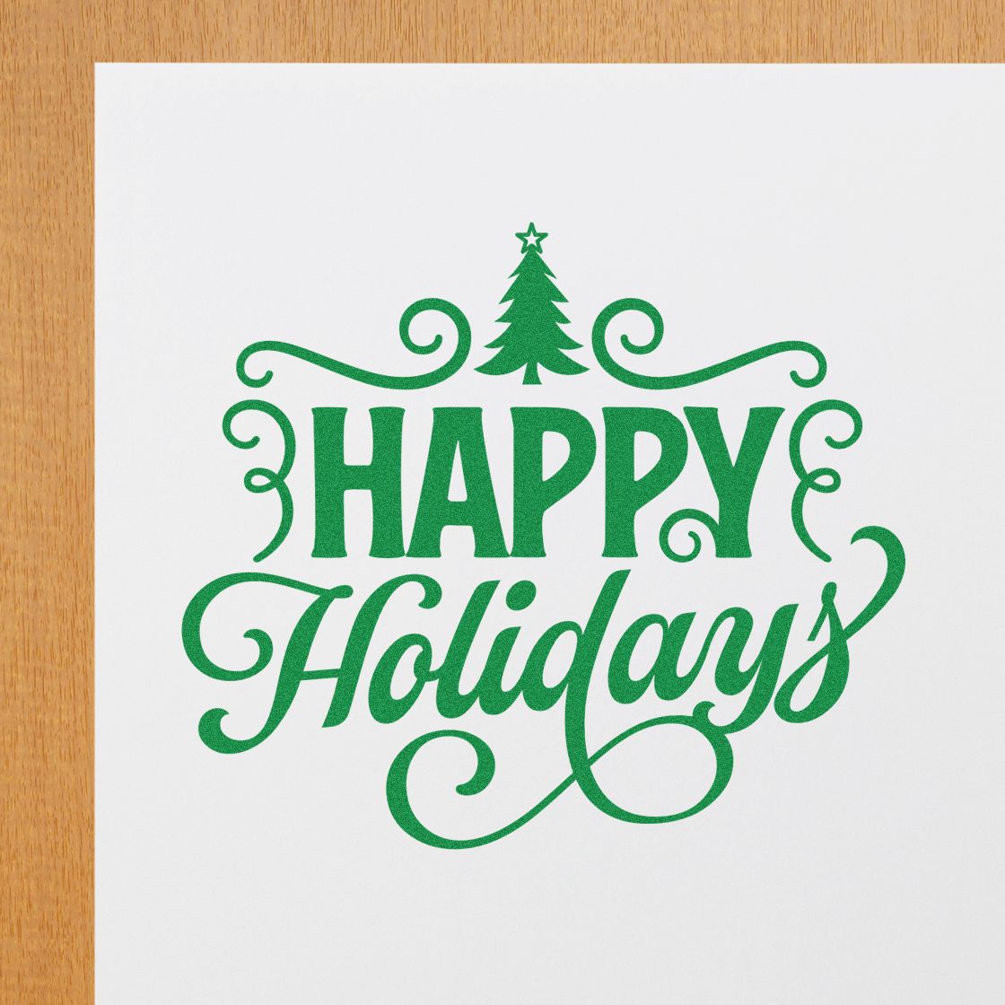 Green Happy Holidays stamp seal with pine tree on white paper, featuring decorative swirls and festive script.