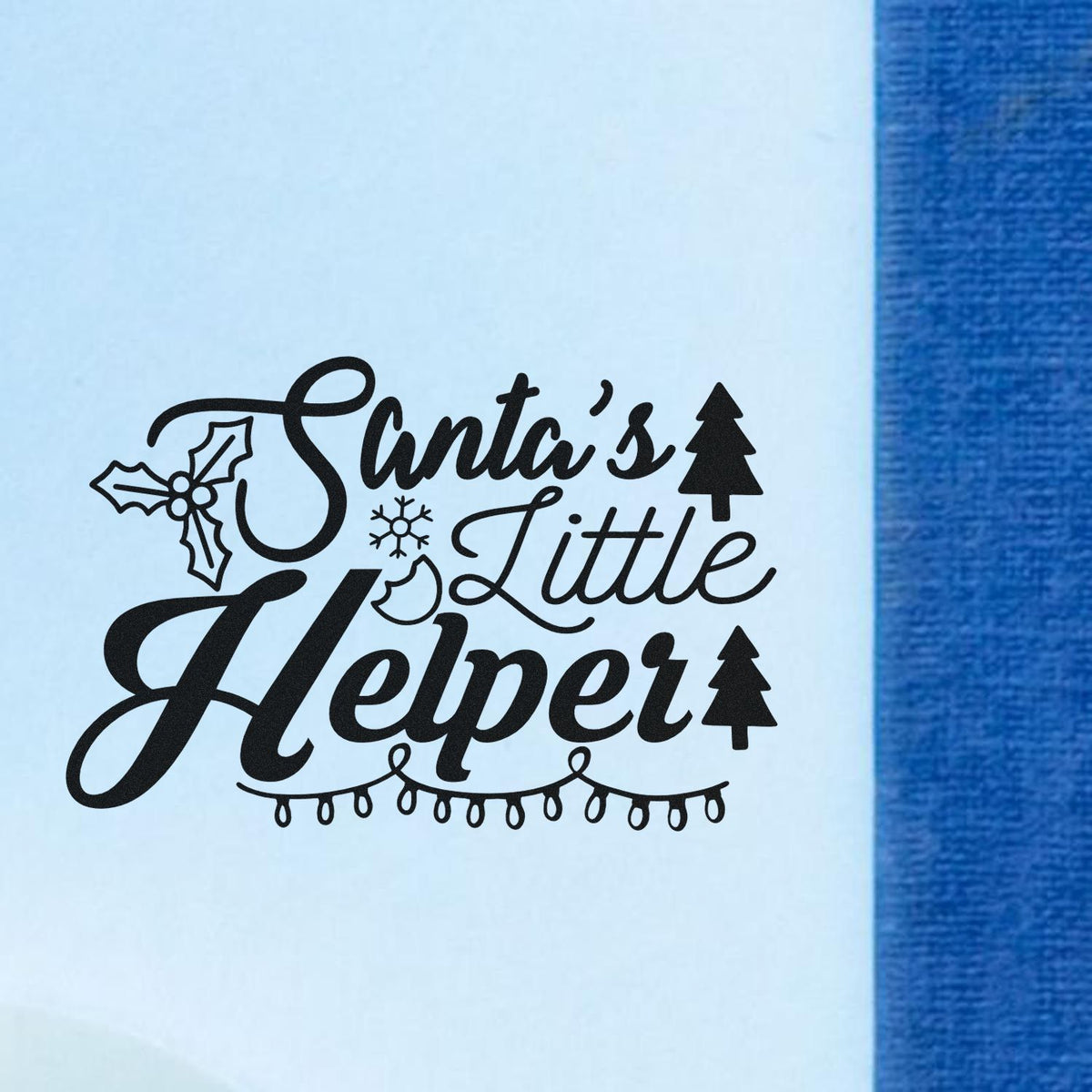 Black Santas Little Helper holiday stamp and seal design with holly, snowflake, tree and string lights on light blue background.